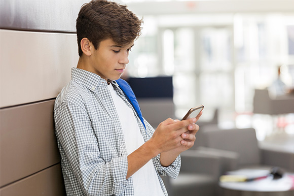 A teen using his mobile phone