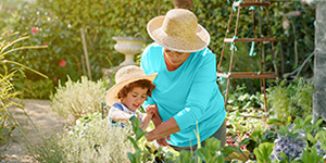 Grandmother and grandchild working in a garden