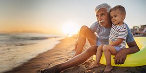 Grandfather and grandson sitting on a beach