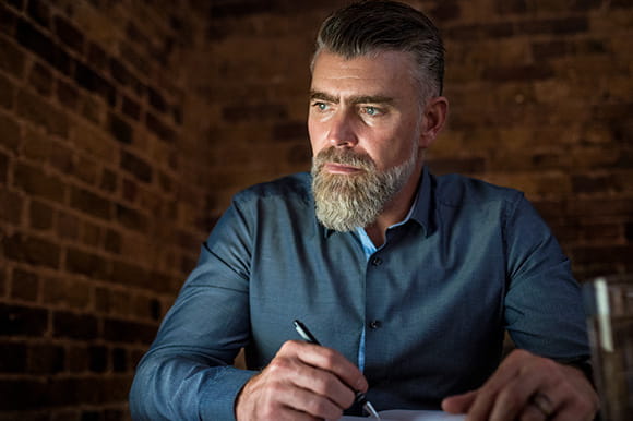 A man with a beard doing paperwork