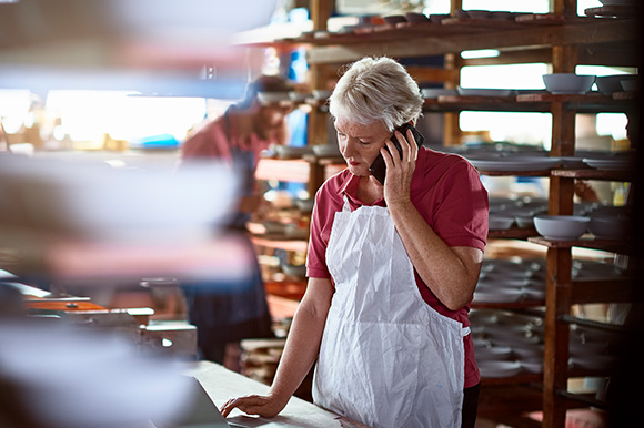 A restaurant owner taking a call in the kitchen